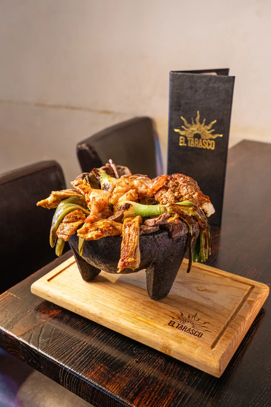 A close look at the molcajete, stacked with grilled shrimp, chicken, steak and cactus